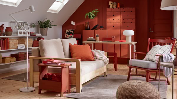 A TORNSBORG sofa-bed stands in a family room with a grey TIDTABELL rug and red-painted pinewood storage.