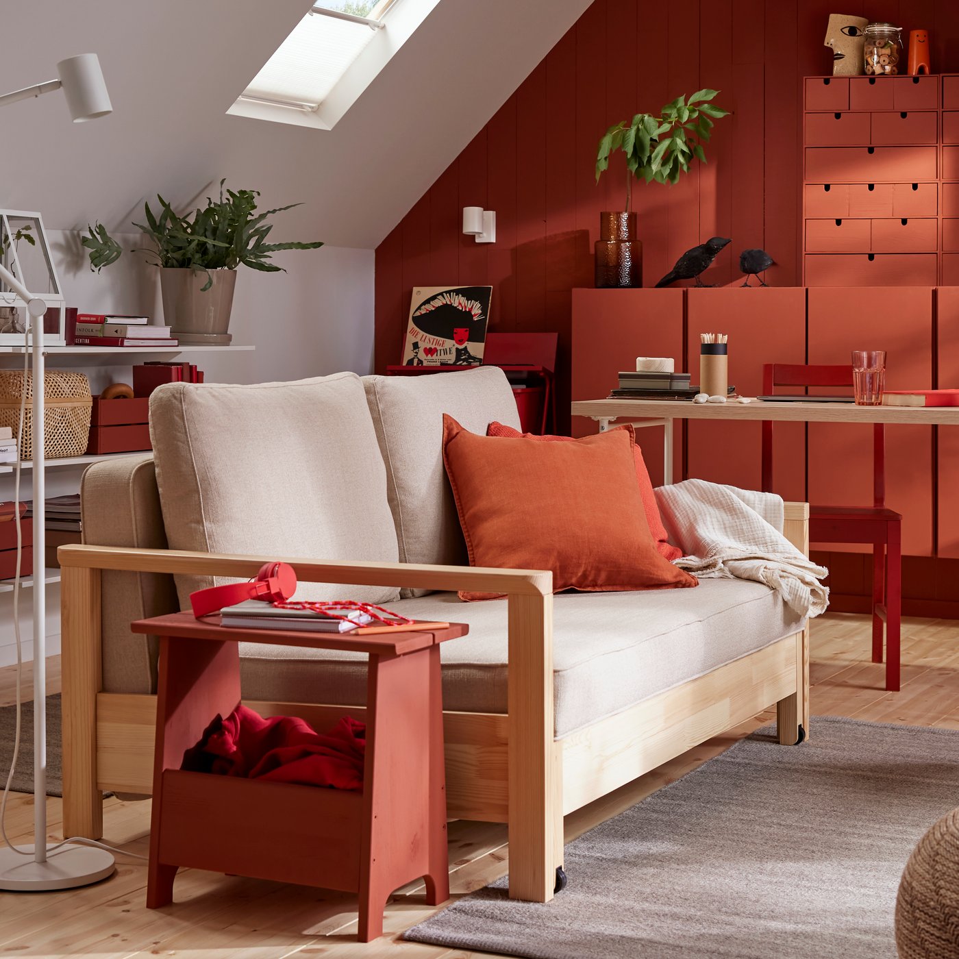 A TORNSBORG sofa-bed stands in a family room with a grey TIDTABELL rug and red-painted pinewood storage.