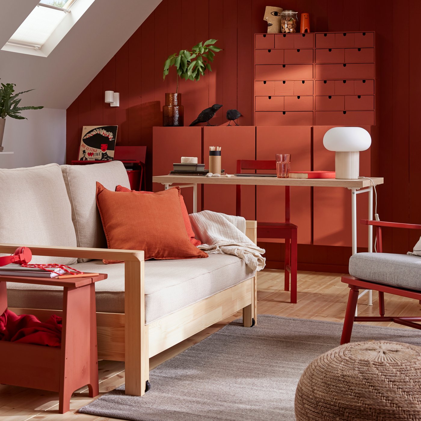 A TORNSBORG sofa-bed stands in a family room with a grey TIDTABELL rug and red-painted pinewood storage.