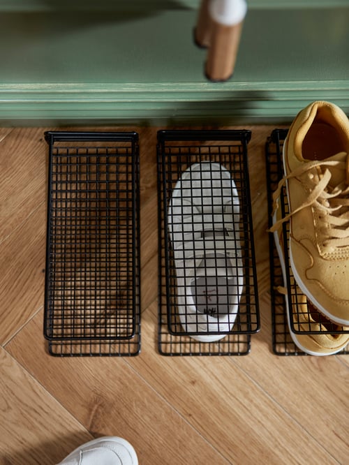 Overhead shot of three SKOSTALL shoe organisers, a pair of cream-brown shoes, and a pair of white shoes.
