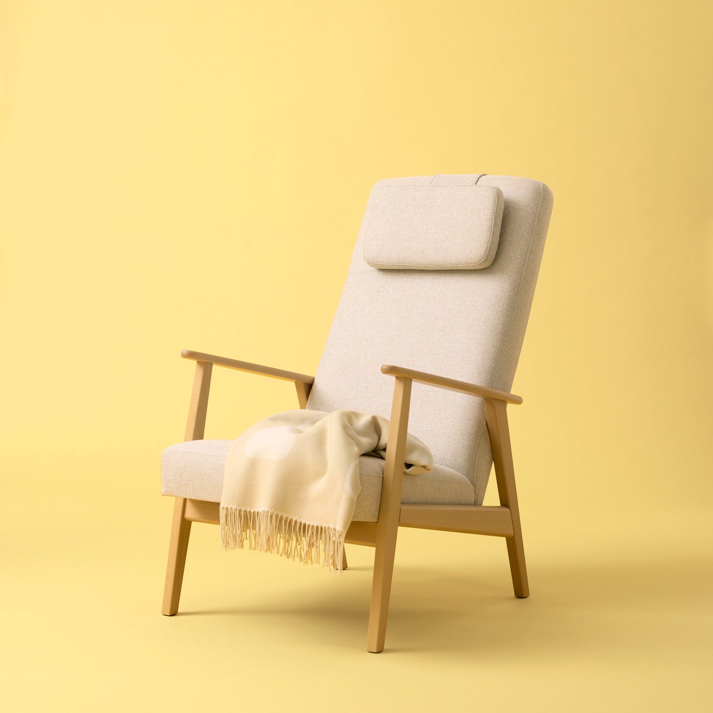 A light-beige EKENÄSET high-back armchair placed against a yellow background, a light throw resting on its seat.