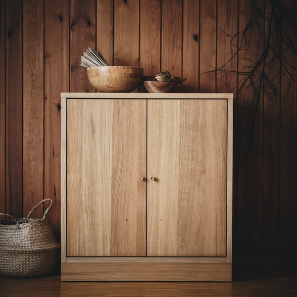 A LAPPTÅG throw lies on a bed. In one of the drawers of the bed, there is a cushion and a VALLKRASSING throw.