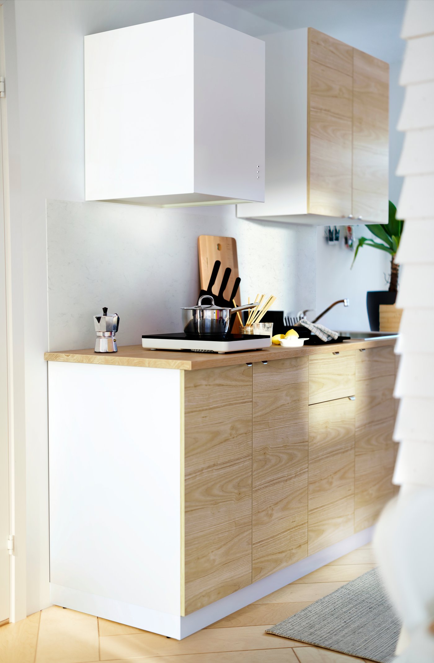 IKEA METOD skabe med ASKERSUND glatte fronter med asketræseffekt og en træbordplade med en transportabel kogeplade.