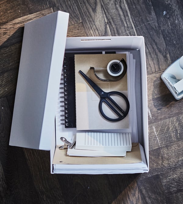 Use a uniform mix of modern home office furniture in your living room work spot. Put office supplies like scissors, tape and papers inside a smart paper box with cut out handles. Try the IKEA TJENA white storage box made from at least 80% recycled paper!