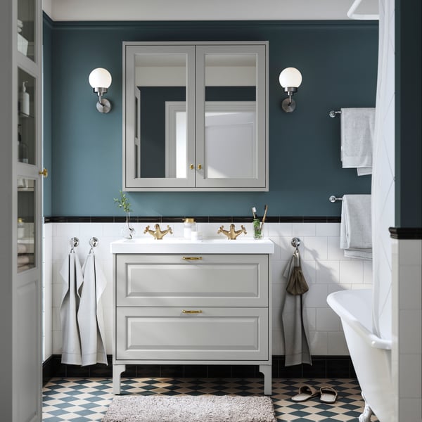 Mueble de lavabo TÄNNFORSEN con lavabo ORRSJÖN en baño con espejo, iluminación de pared y toallas.