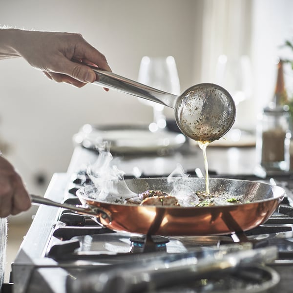 Personne en train de cuisiner avec une poele IKEA.