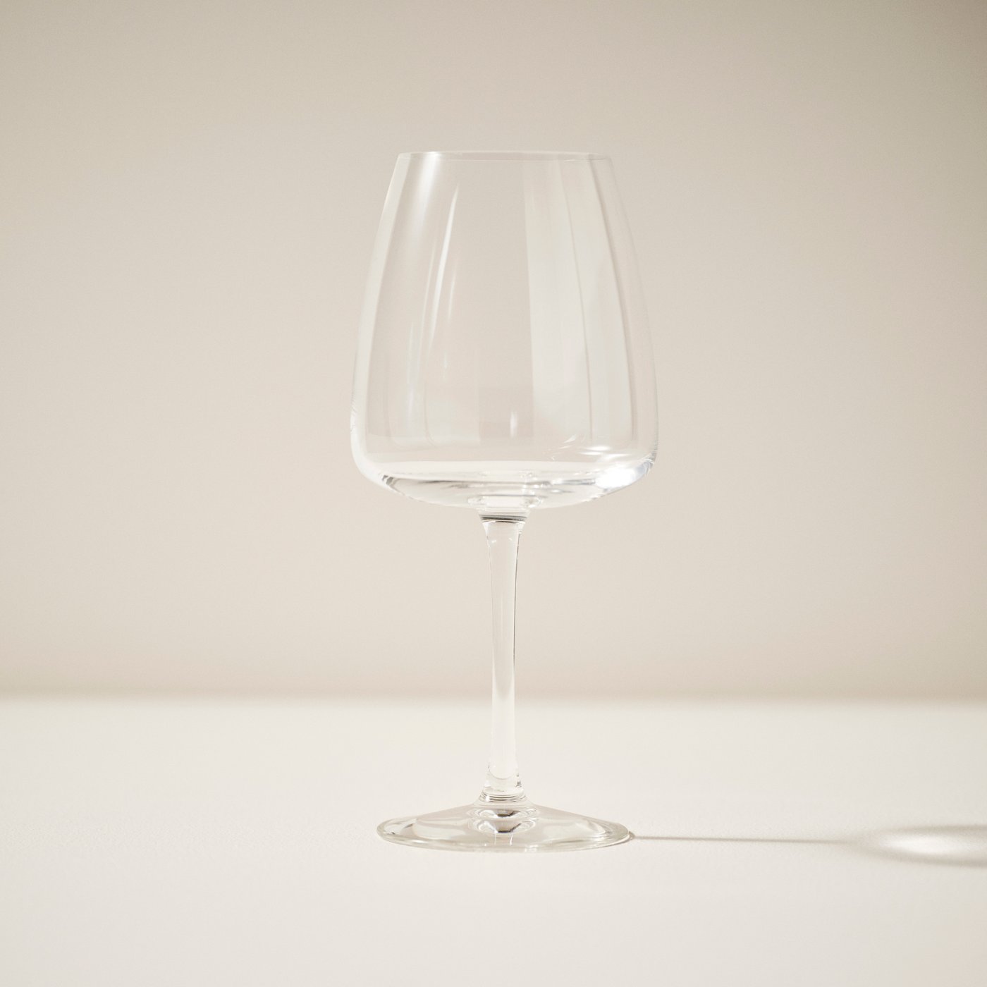 A clear glass DYRGRIP red wine glass in the NA