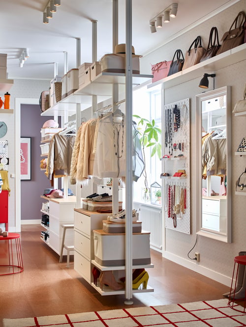 A five-section, white/bamboo ELVARLI storage system is attached to a hallway ceiling. It holds coats, boxes and shoes.