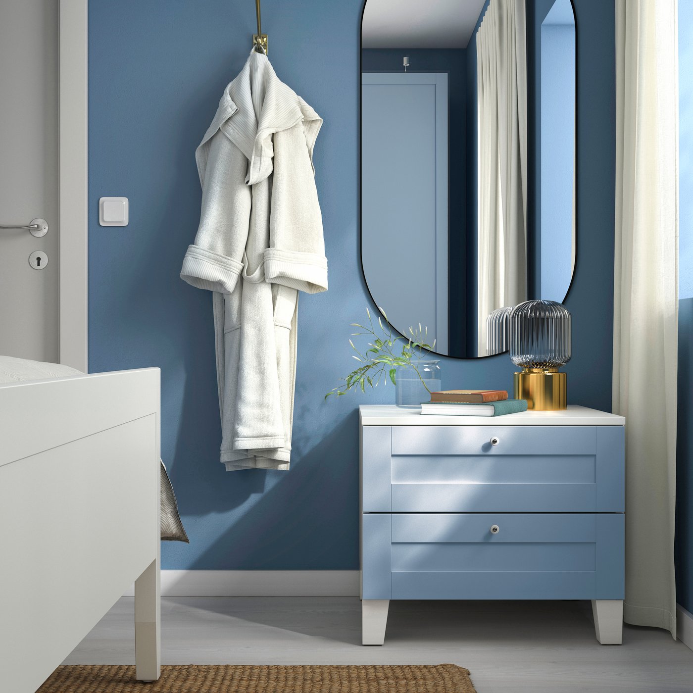 A white/Sannidal blue PLATSA chest of 2 drawers in the bedroom. Above PLATSA sits a black LINDBYN mirror mounted on the bedroom wall.