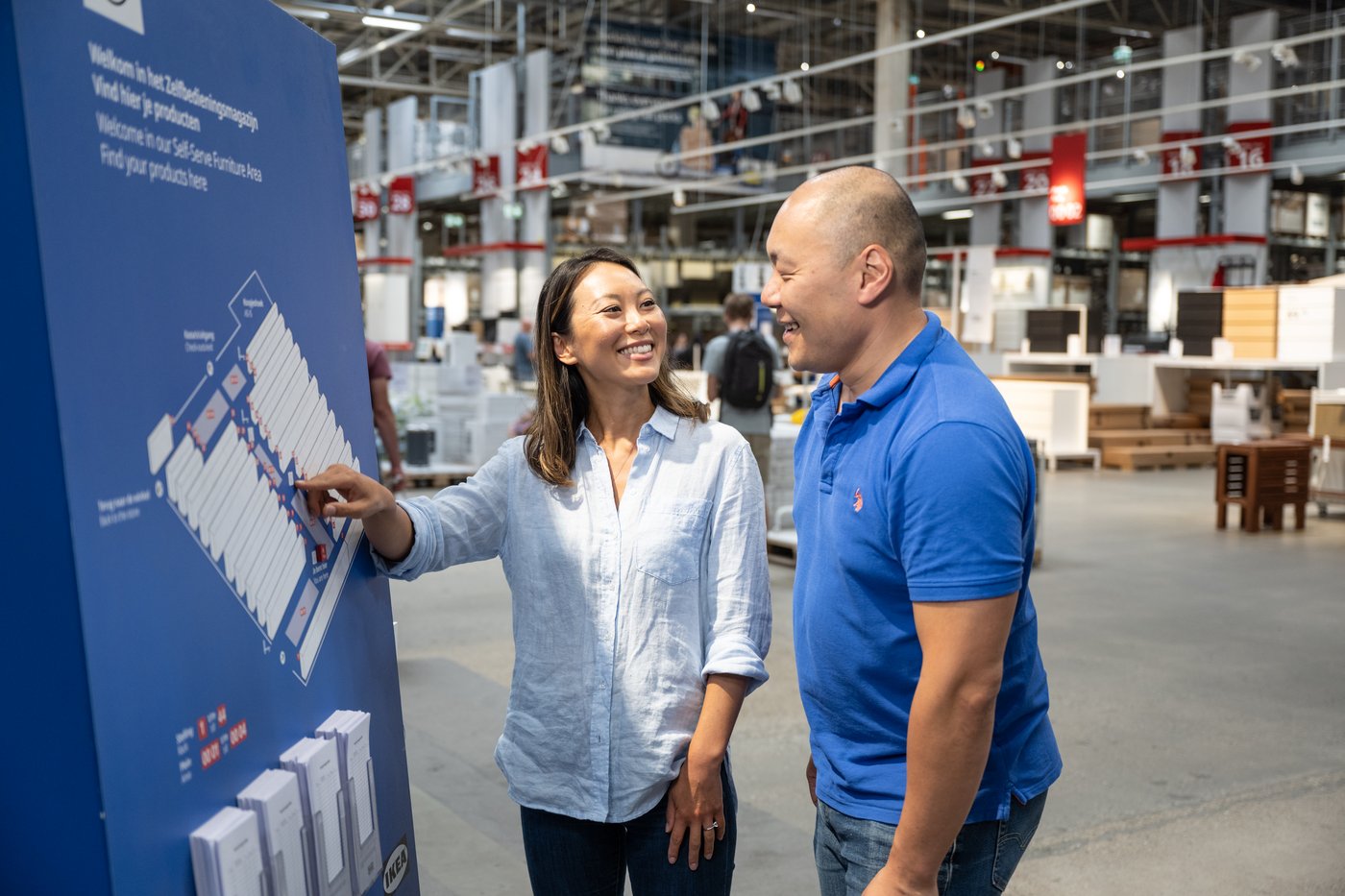 Two IKEA customers happily looking at the store directions