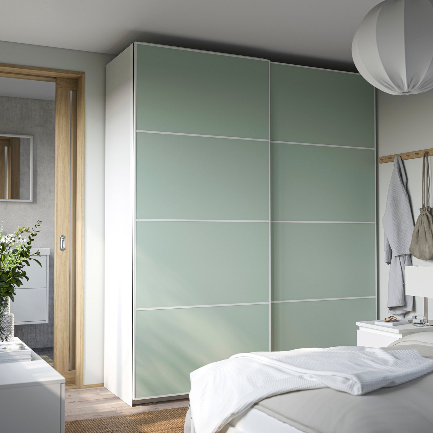 Ein weißer PAX Kleiderschrank mit zwei hellgrünen Schiebetüren.