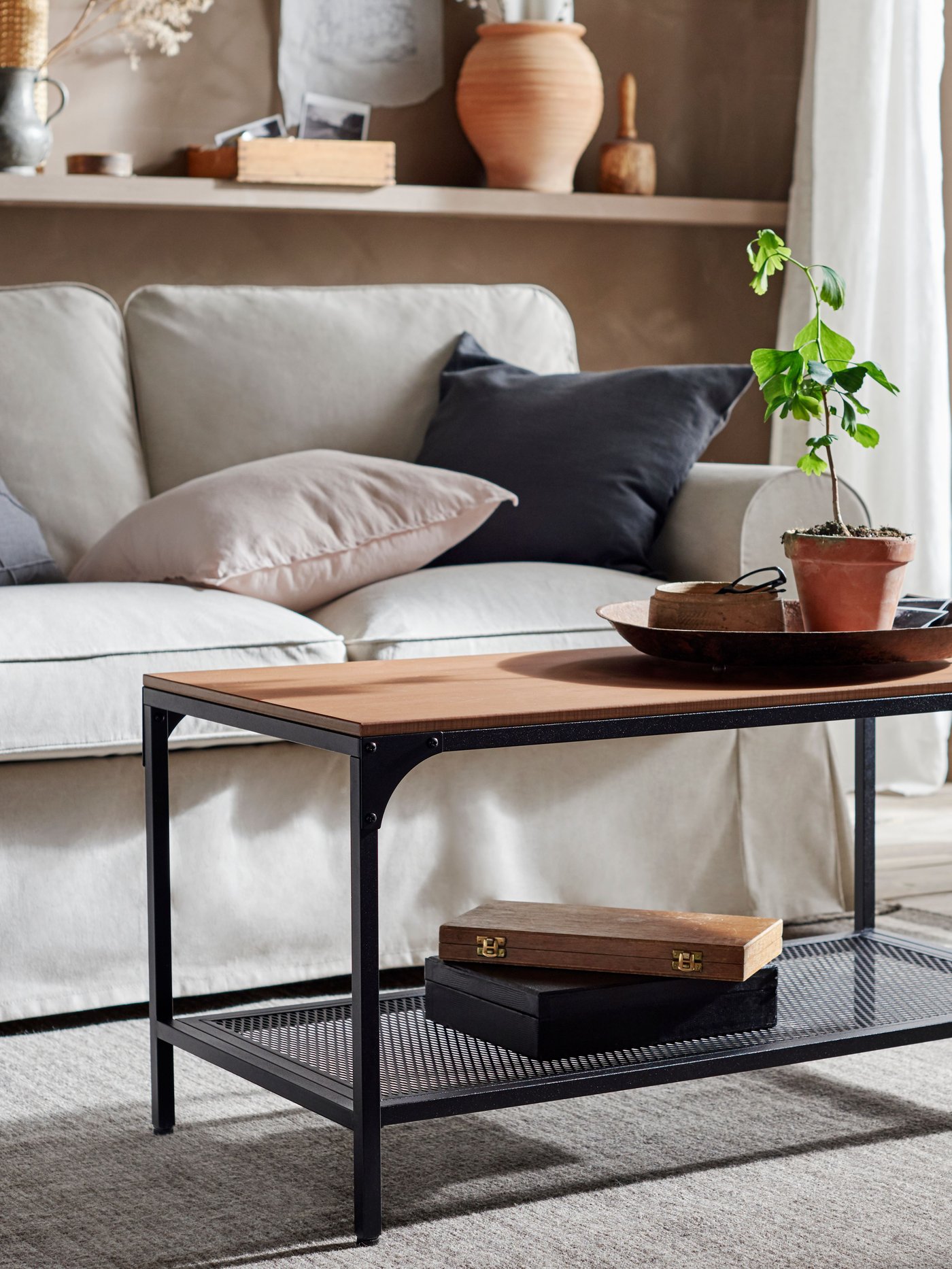 Mesa de centro FJÄLLBO frente a un sofá beige.