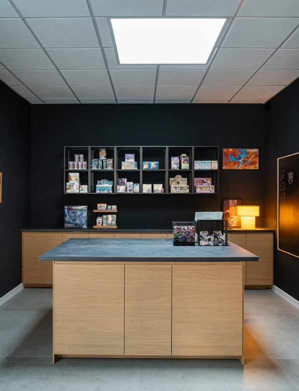 L'angolo del negozio per la cassa e gestione dei pagamenti con scaffalature a parete e a centro stanza per esporre manga, fumetti, gadget e action figure.