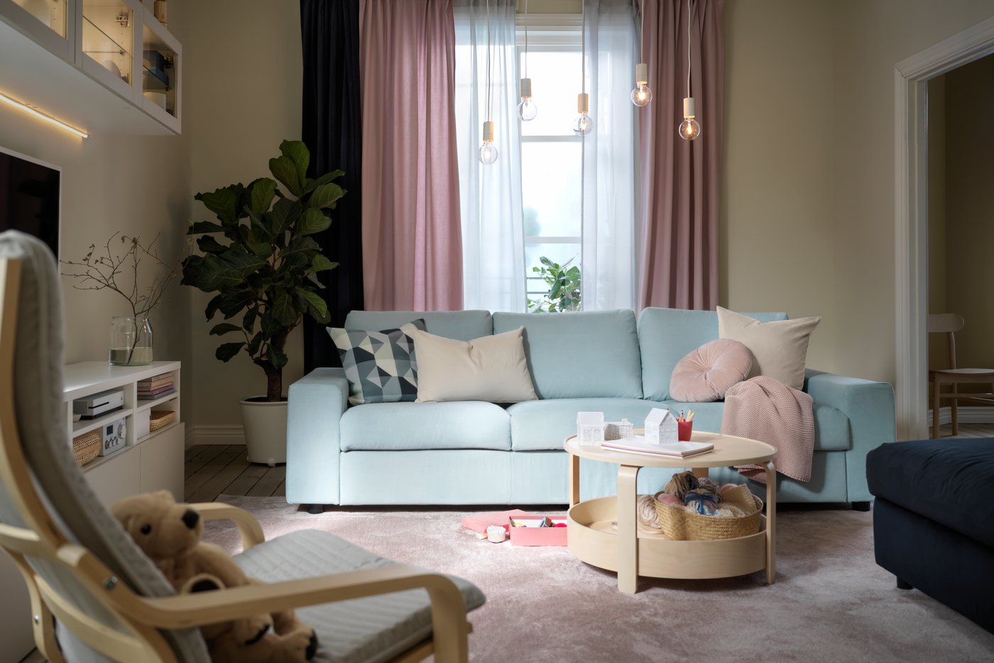 A child-friendly interior with a playful layout of the living room. A blue VIMLE sofa is in the middle of the room. In front of the sofa is a BORGEBY coffee table with storage space.