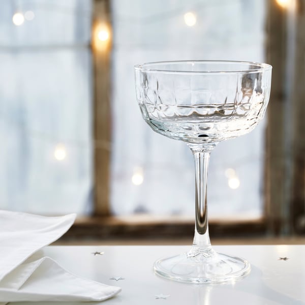 A clear glass FRÖJDA champagne coupe