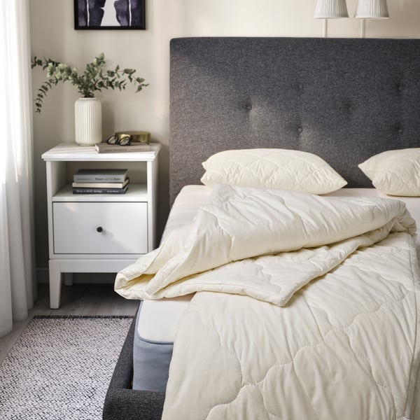 A RÅDHUSVIN duvet on an upholstered bed