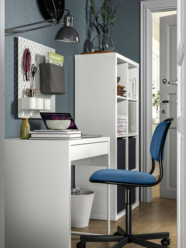 A room setting featuring a MICKE desk, ÖRFJÄLL swivel chair in blue and KALLAX shelf by the side.