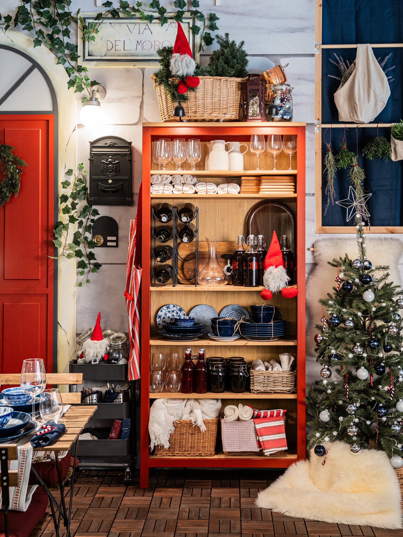 Una libreria HEMNES color rosso/marrone chiaro con decorazioni natalizie VINTERFINT.