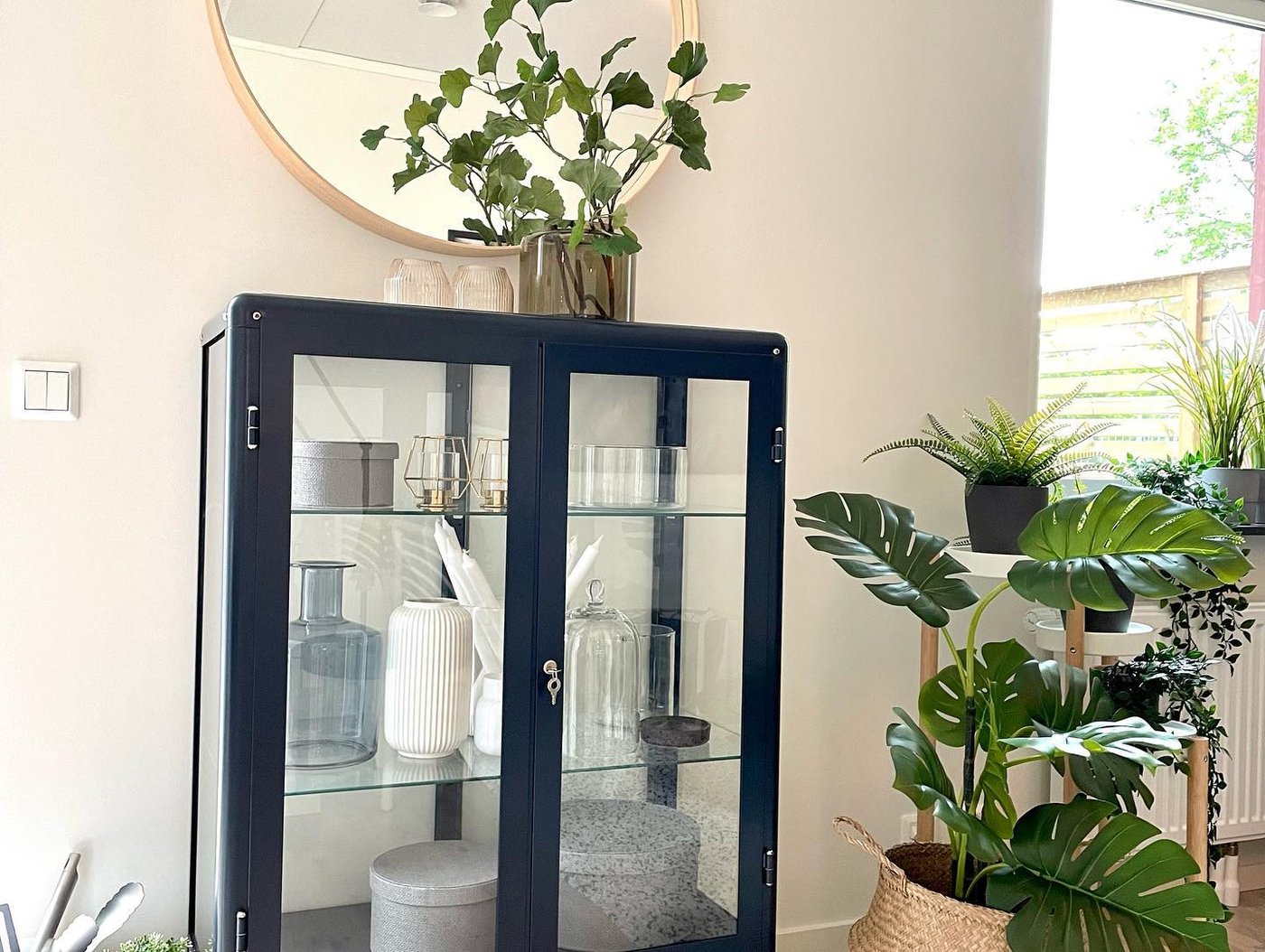 Un armario con puerta de cristal FABRIKÖR azul-negro en el salón
