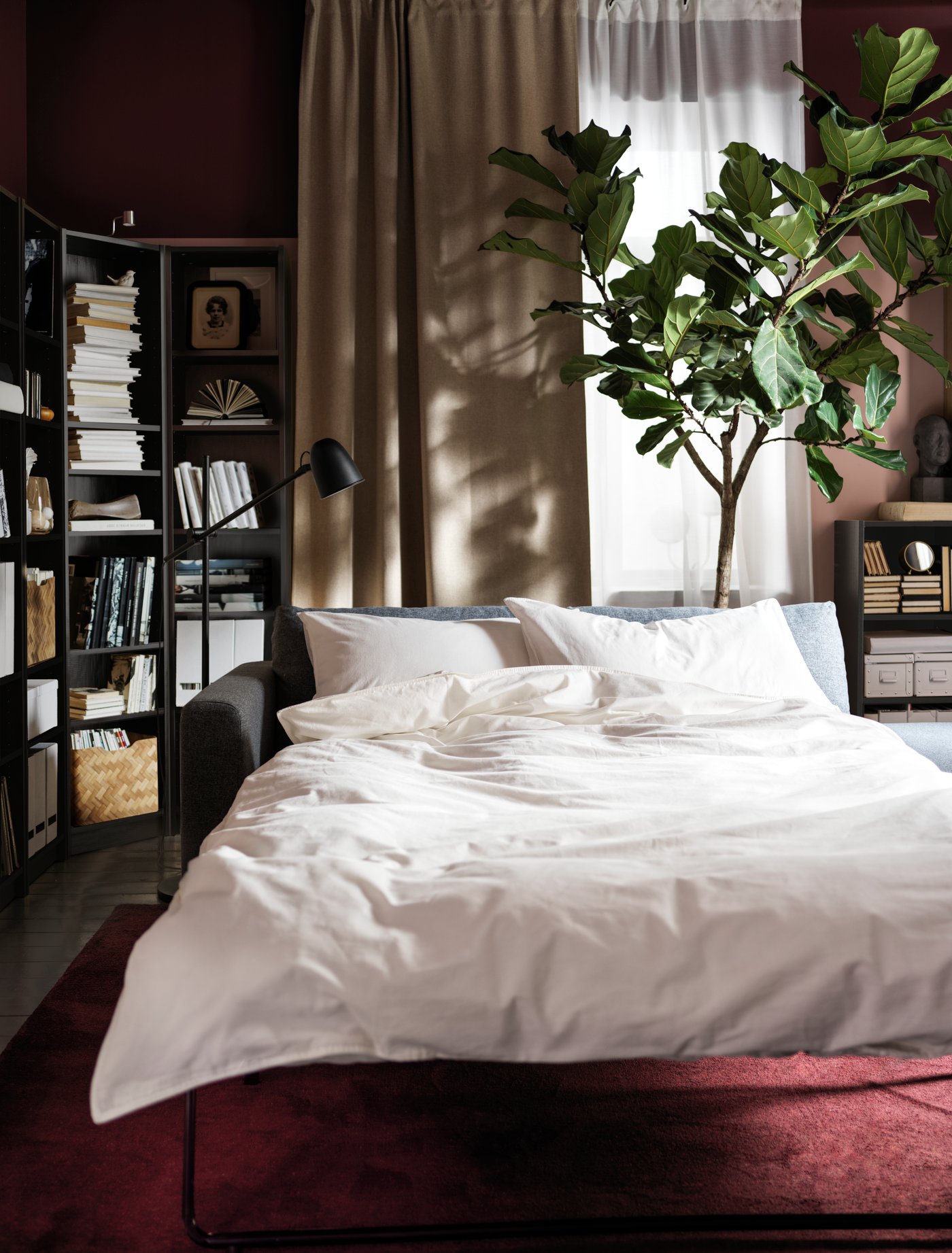 A black SKURUP floor/reading lamp in the bedroom