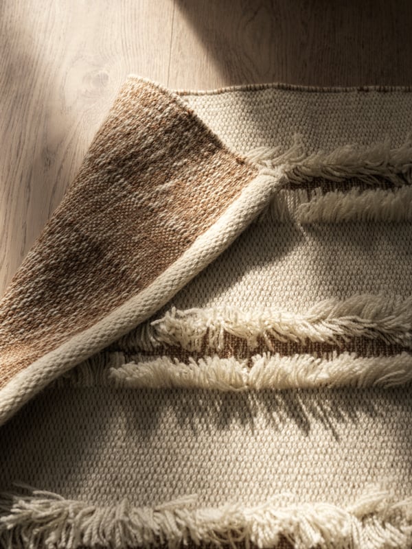 A natural/off-white PEDERSBORG rug, flatwoven in the living room