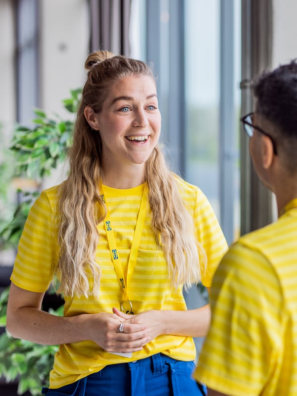 Two co-workers chatting happily in an IKEA store.