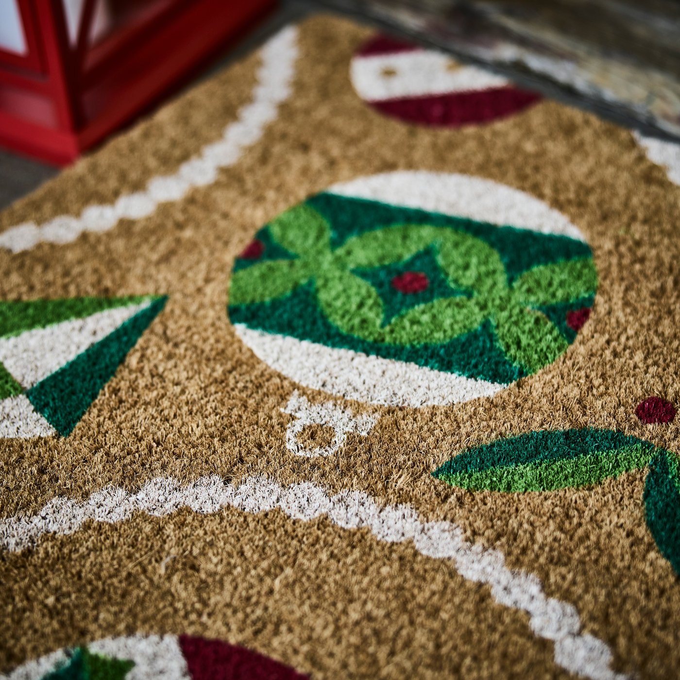 Dettaglio di uno zerbino VINTERFINT in fibra di cocco/multicolore con motivo decorativo a palline di Natale.