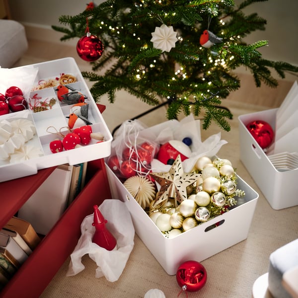 A white KUGGIS storage box and a white KUGGIS insert filled with VINTERFINT tree decorations.
