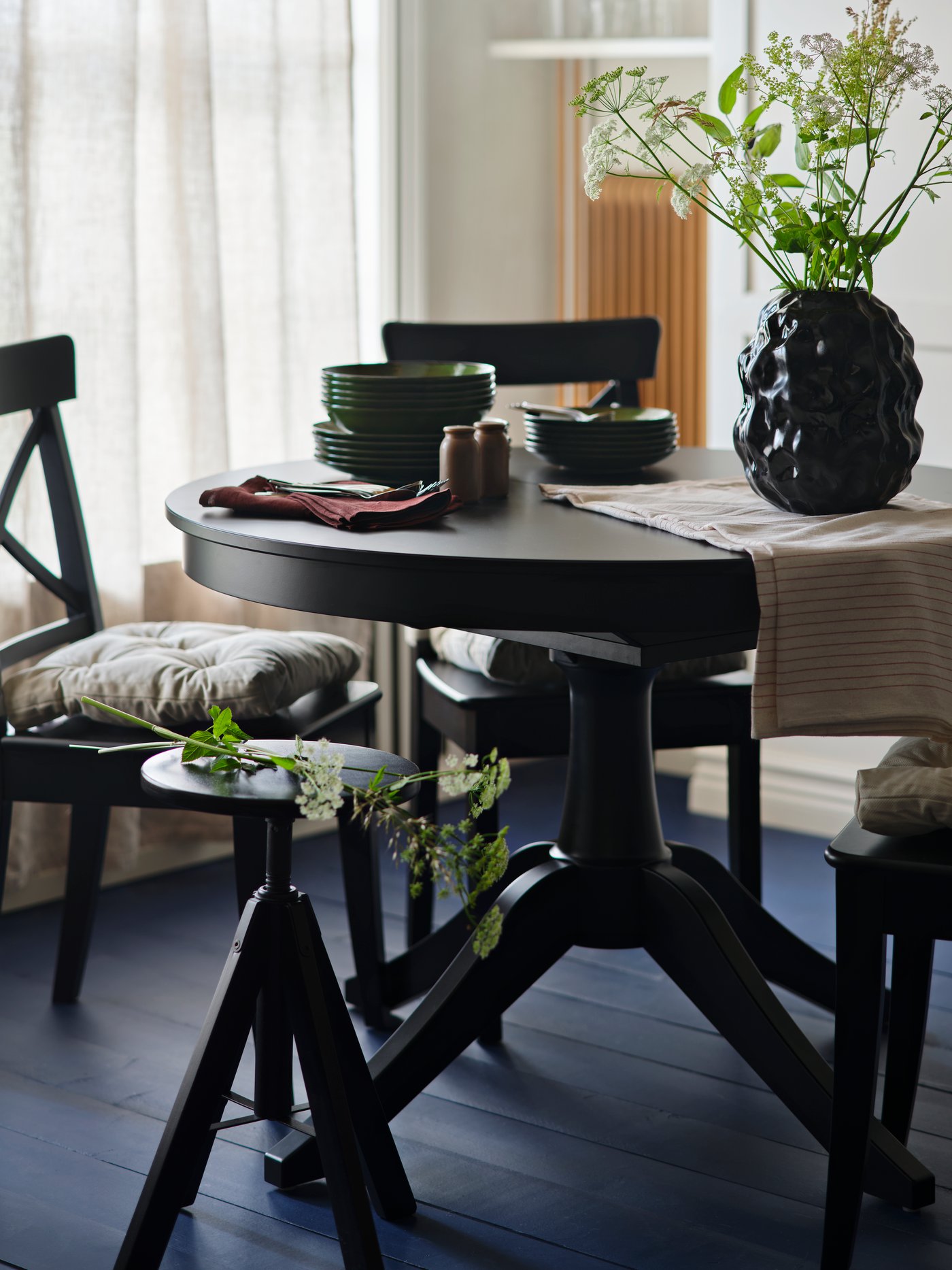 Lampa SANDKORN wisząca nad stołem z krzesłami.