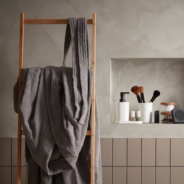 A grey ROCKÅN bath robe in the bathroom