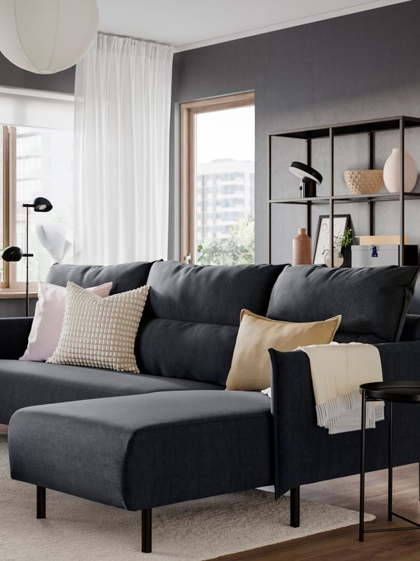 An off-white SVARTPOPPEL cushion cover in the living room