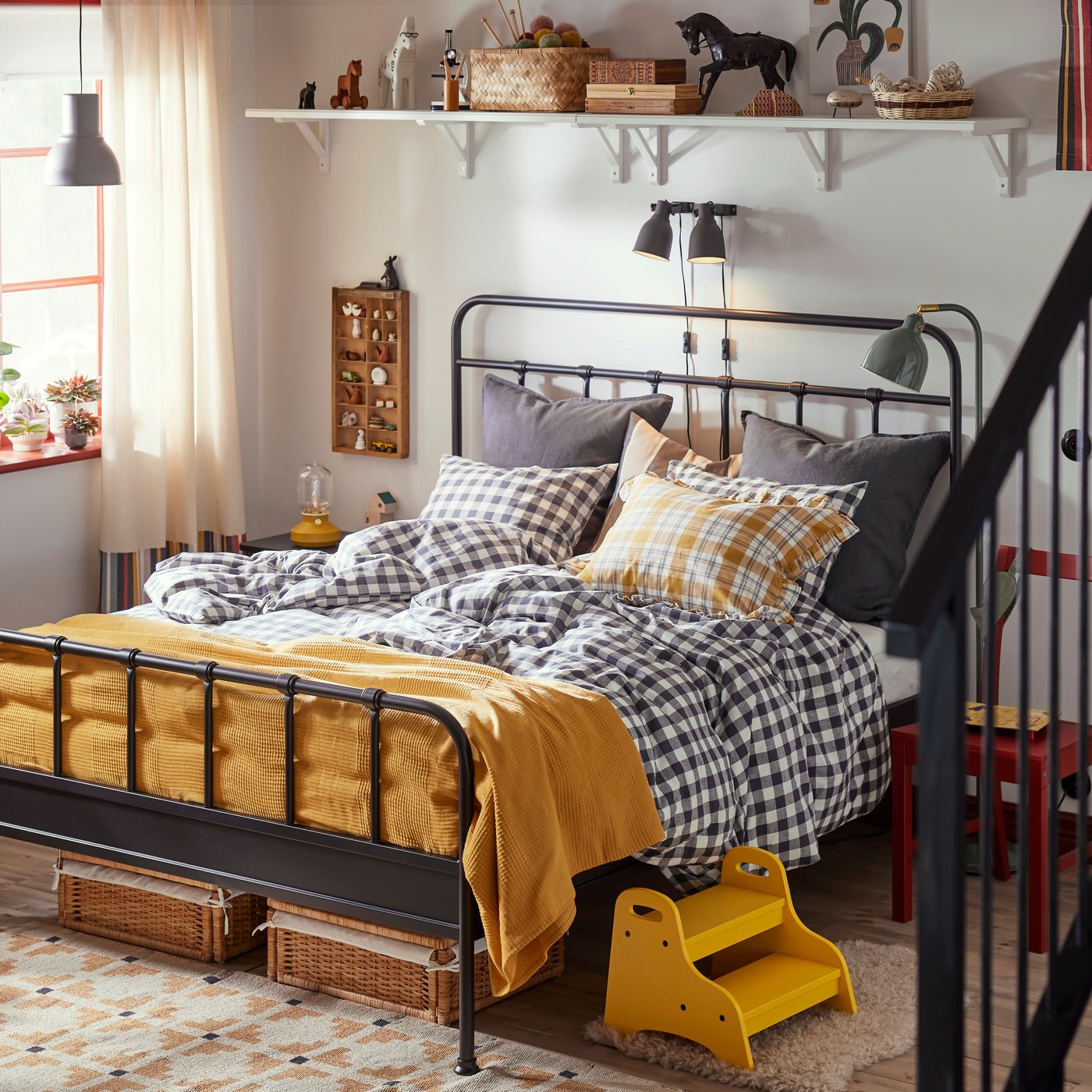 Family bedroom with STJÄRNÖ bed frame in anthracite with checkered sheets. Bedspread and details in bright yellow.
