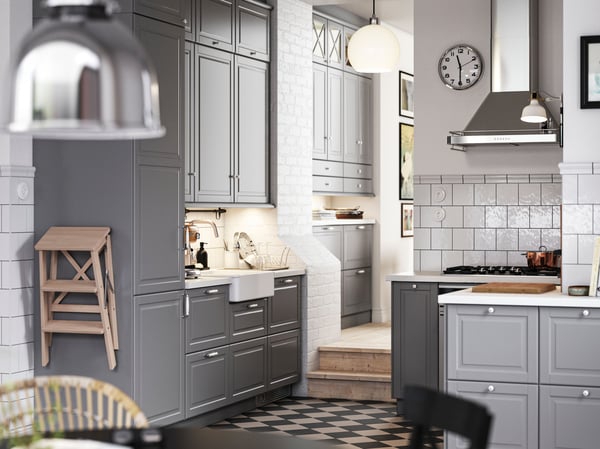 A traditional kitchen with a chequered floor, grey BODBYN kitchen fronts and white/light grey stone effect/laminate countertop.