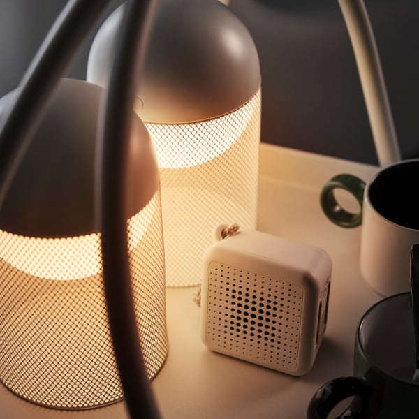A close-up of white SOLVINDEN LED decoration lighting with a mesh design and battery-operated globe on a table.