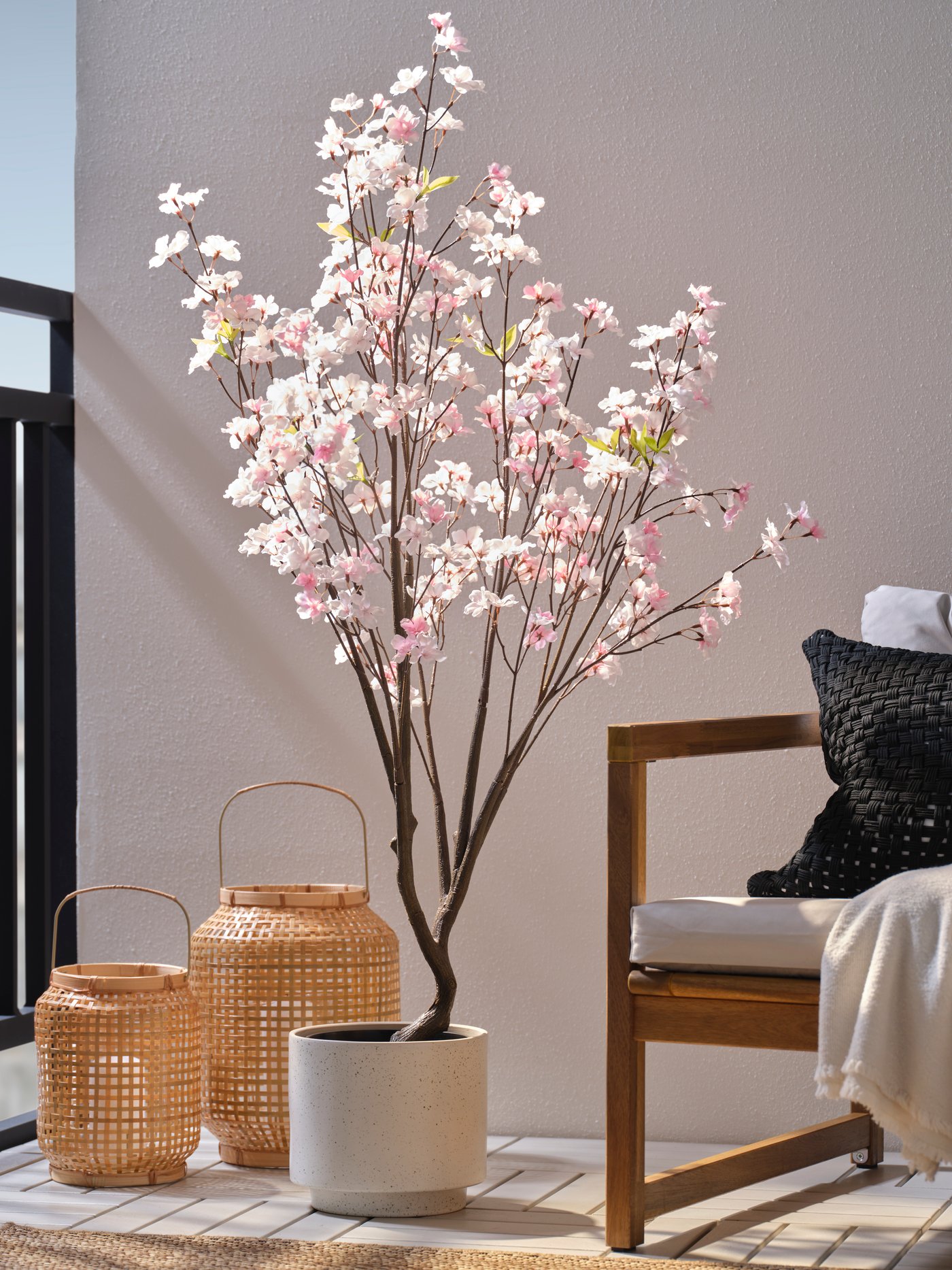 Große Kunstblume in zartem Rosa in einem dekorativen Topf.