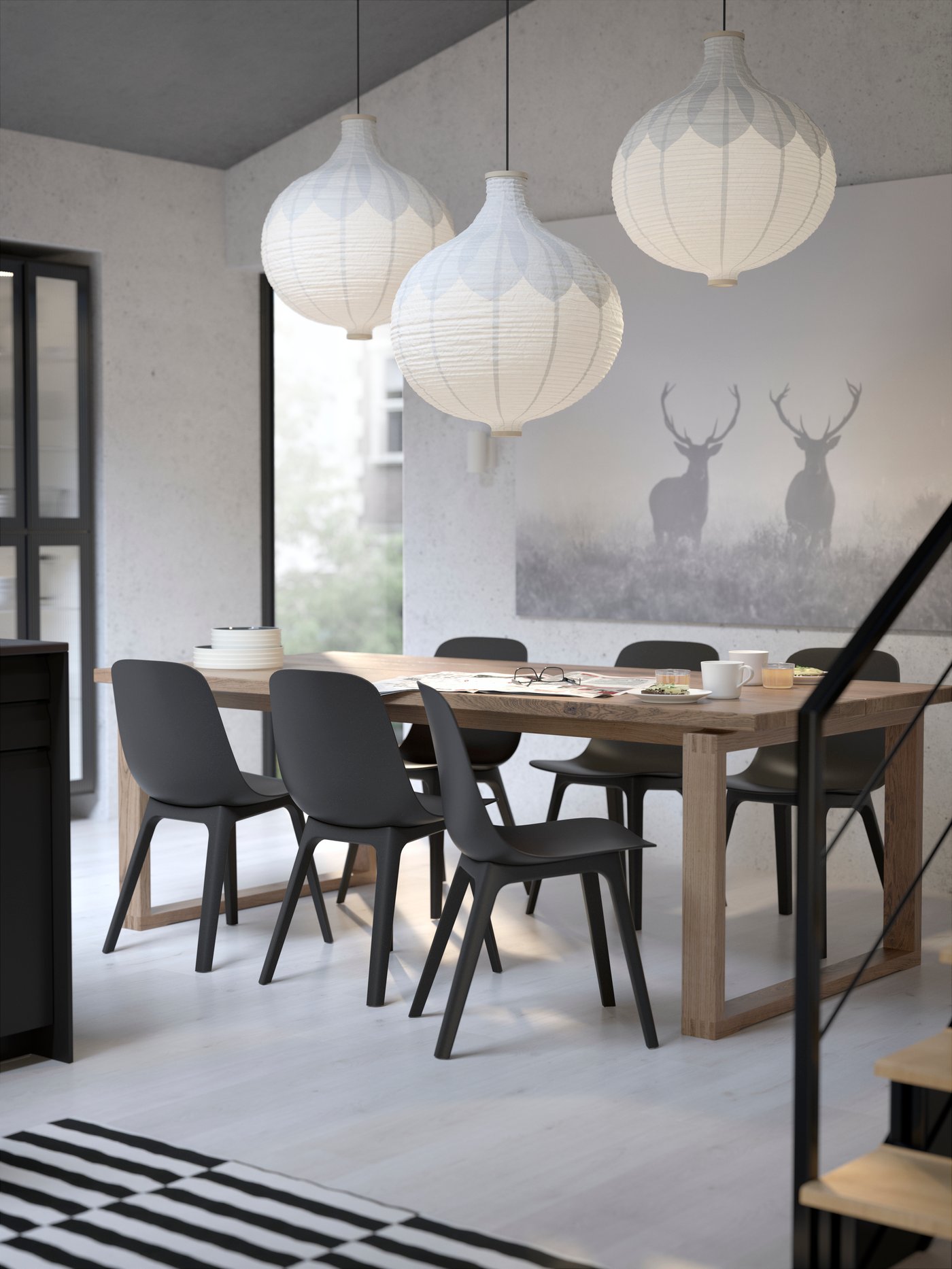Es ist ein Raum mit einem MÖRBYLÅNGA Tisch in braun lasiertem Eichenfurnier, ODGER Stühlen in Anthrazit und Hängeleuchten mit RISBYN Hängeleuchtenschirmen zu sehen.