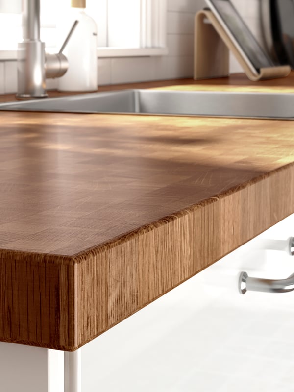 A close-up of the durable SKOGSÅ countertop in oak in a kitchen setting.