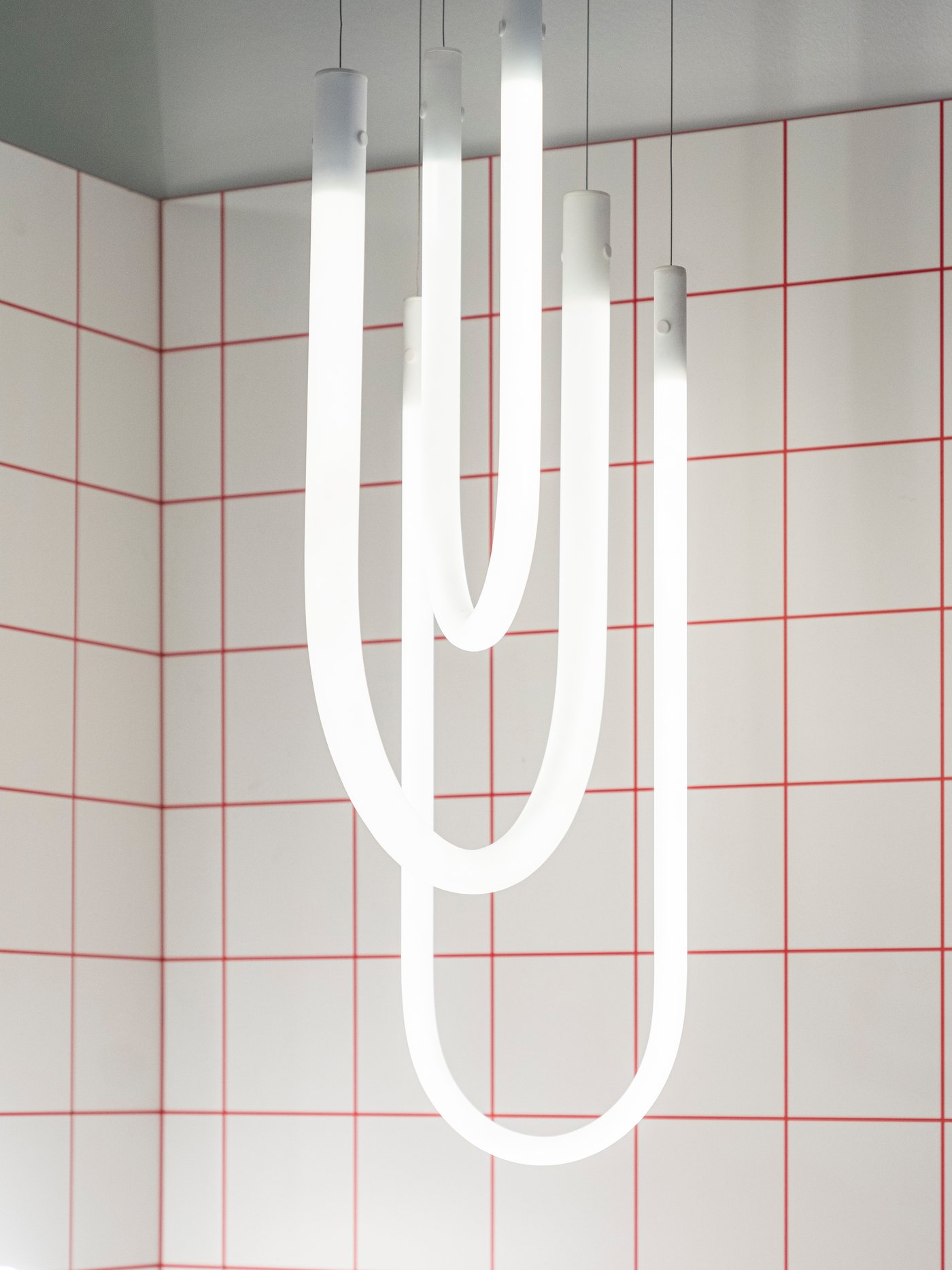 Lampa wisząca VARMBLIXT na tle białych płytek.