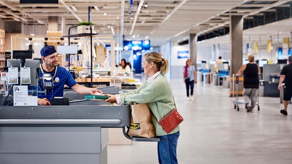 Oseba plačuje na blagajni trgovine iKEA.