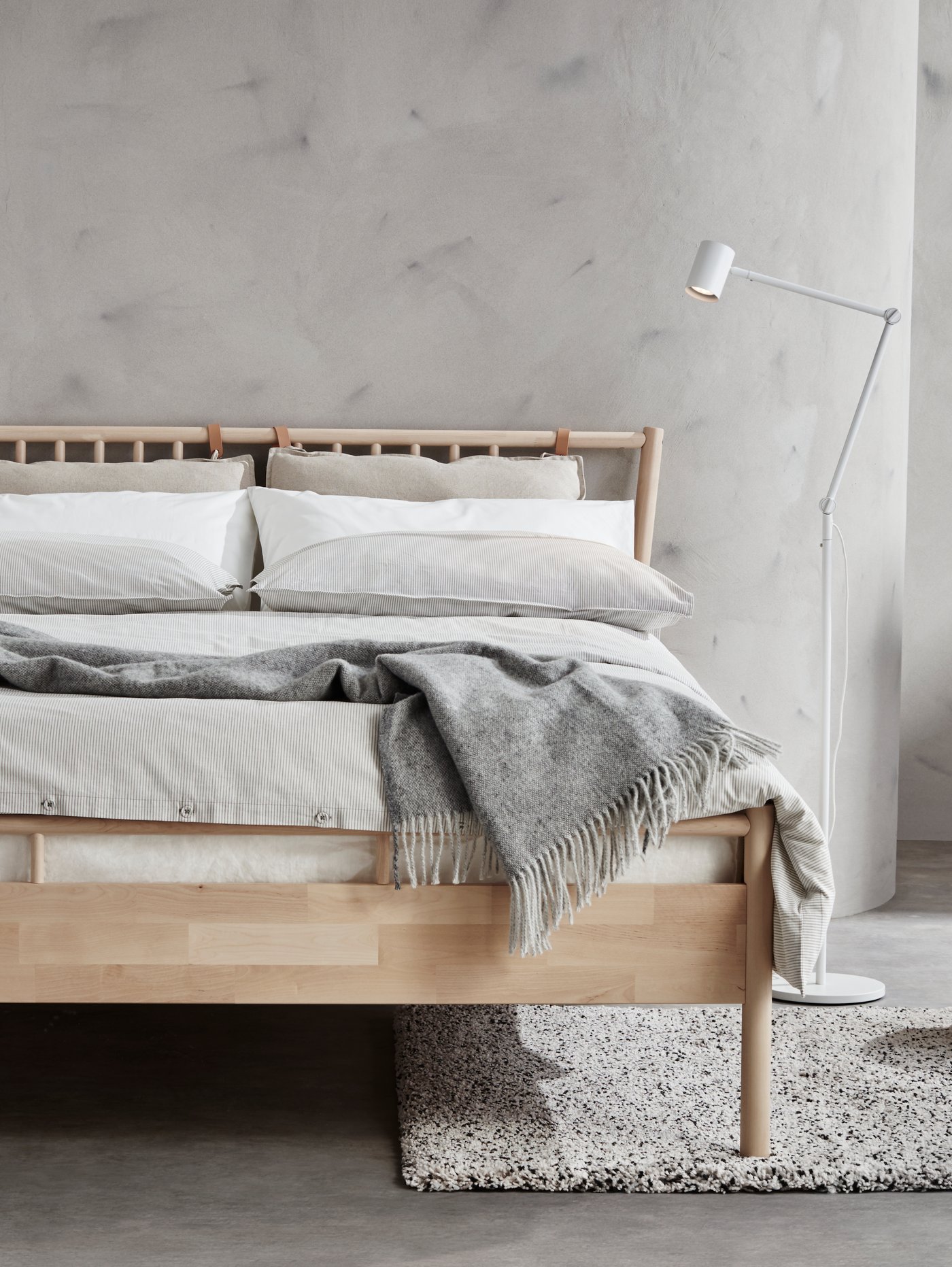 A white NYMÅNE floor/reading lamp in the bedroom