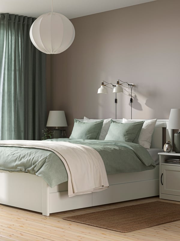 Es ist ein Schlafzimmer in grauen Farben mit eine SLATTUM Bett und einer NORDLI Kommode.