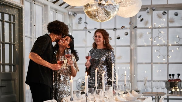 White and silver themed New Year’s Eve dining setting in greenhouse with FRÖJDA hanging decoration, garlands and lighting.