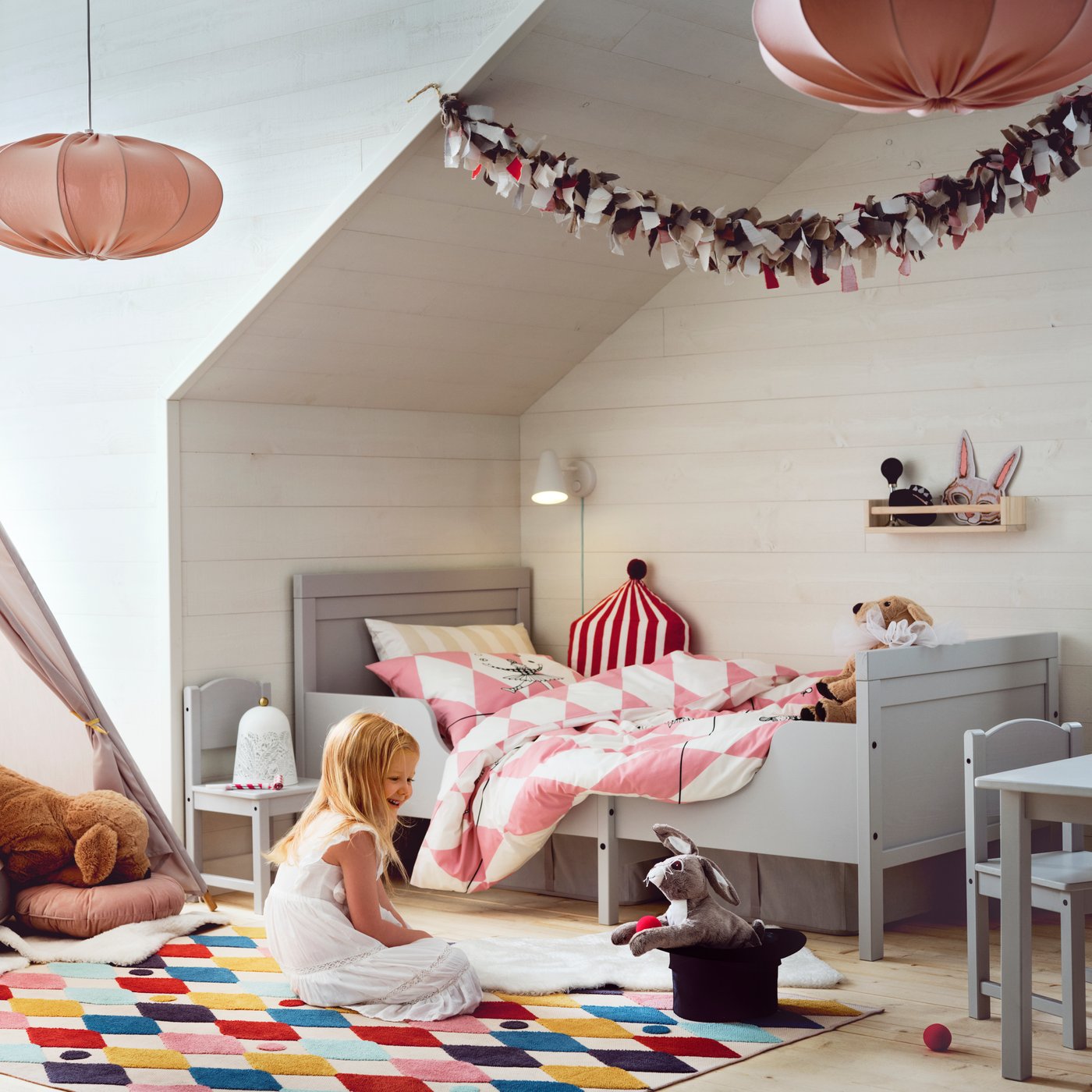 A circus tent shape red/white BUSENKEL cushion in the childrens room