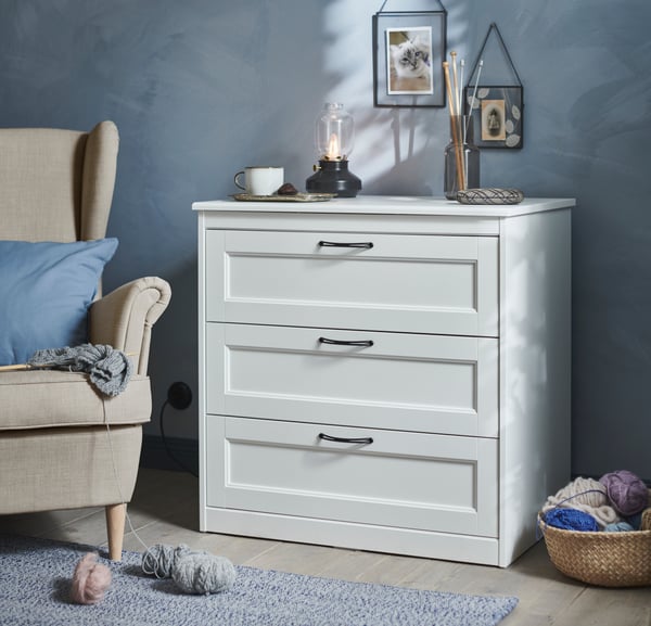A Nordvalla dark grey STRANDMON wing chair in the bedroom