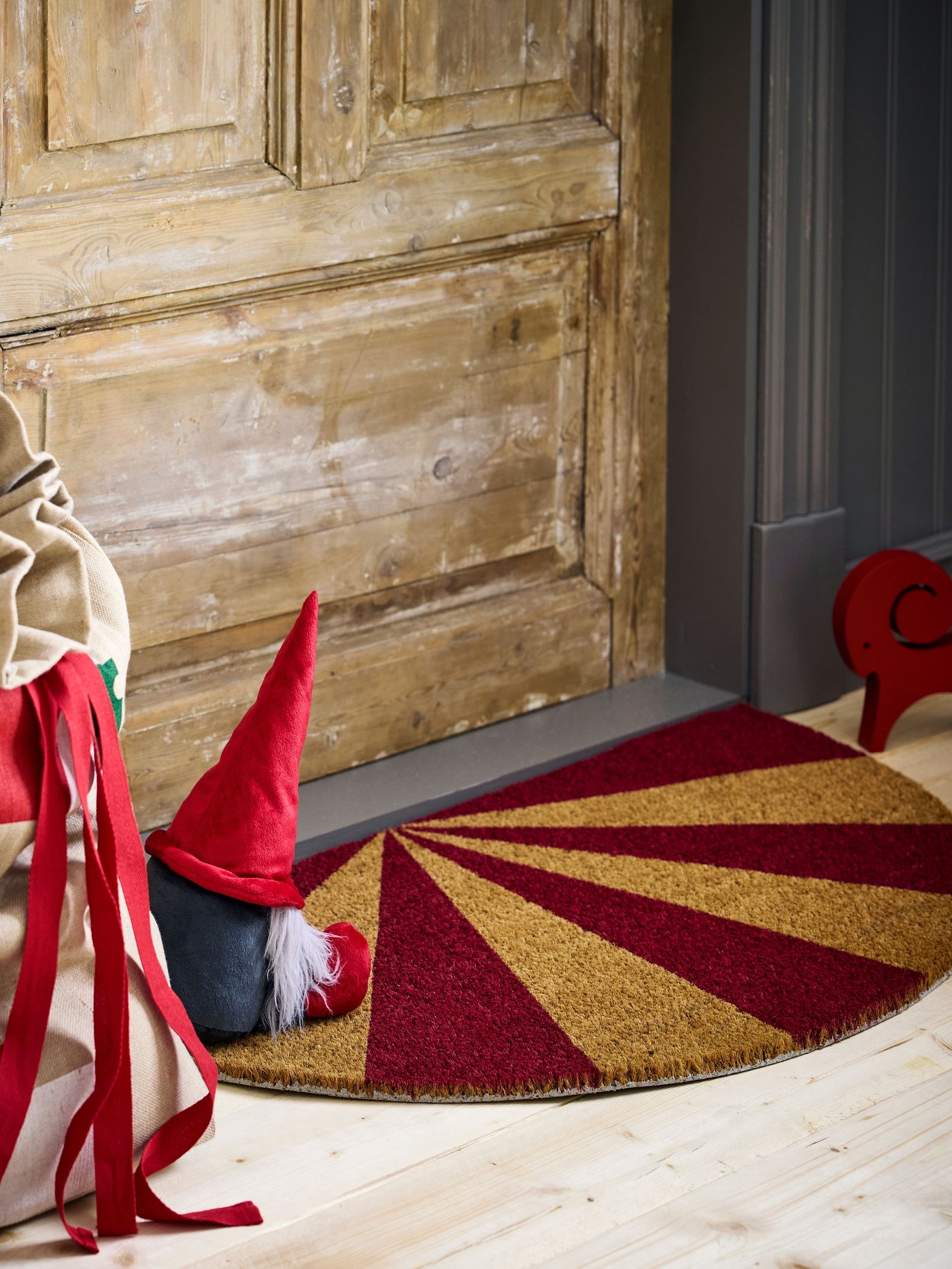 A striped coir/red VINTERFINT door mat
