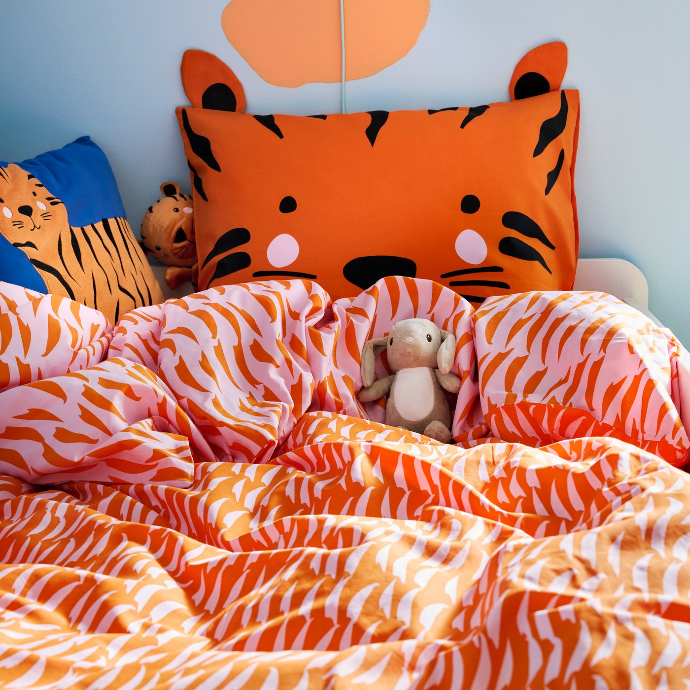 A blue/tiger NATTHÄGER cushion in the childrens room