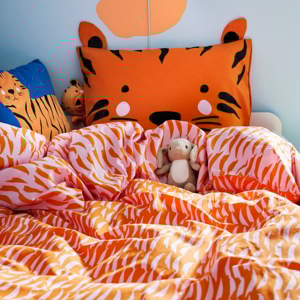 A blue/tiger NATTHÄGER cushion in the childrens room