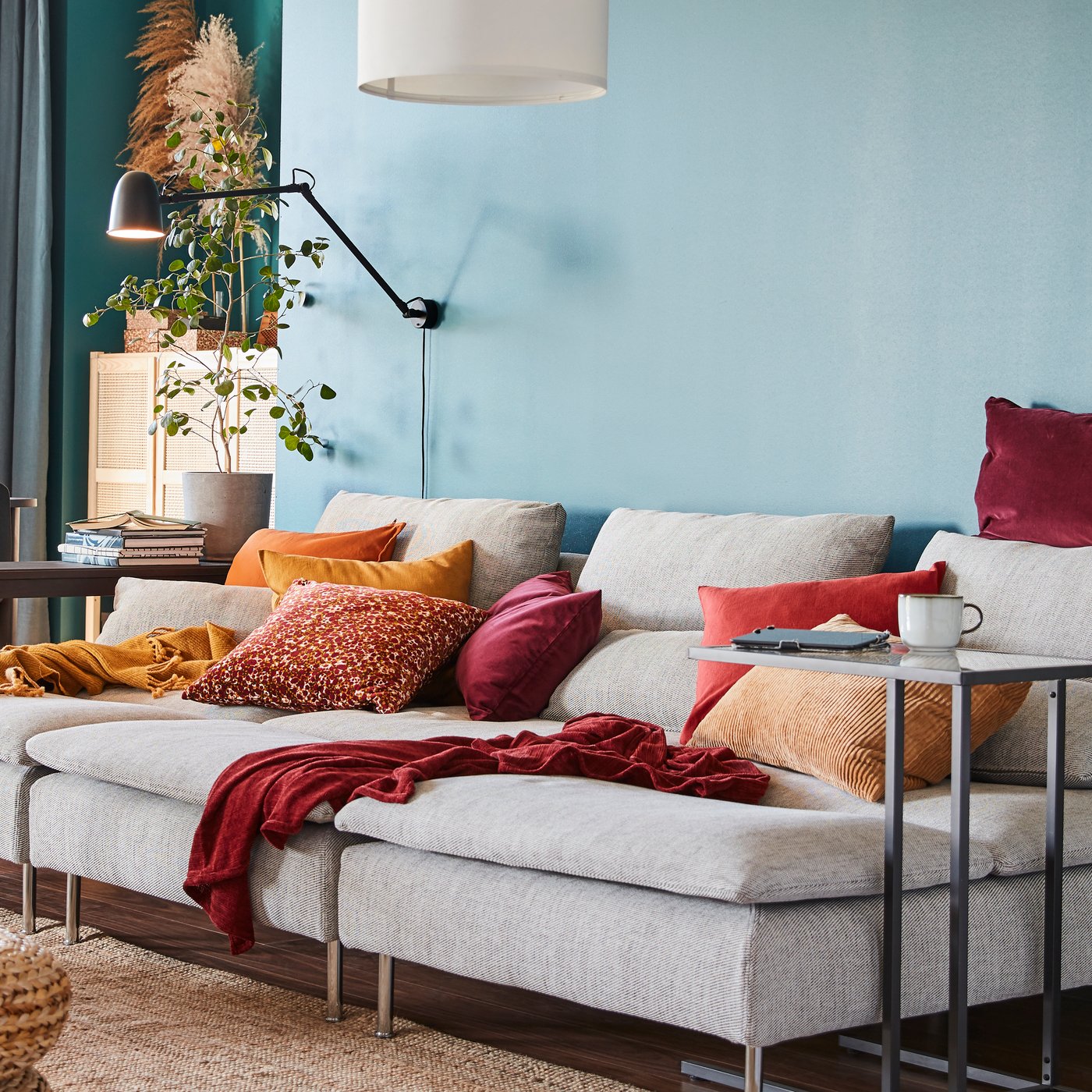Pracovní/nástěnná lampa SKURUP je připevněná na stěně nad třemi lenoškami SÖDERHAMN v barevném obývacím pokoji.