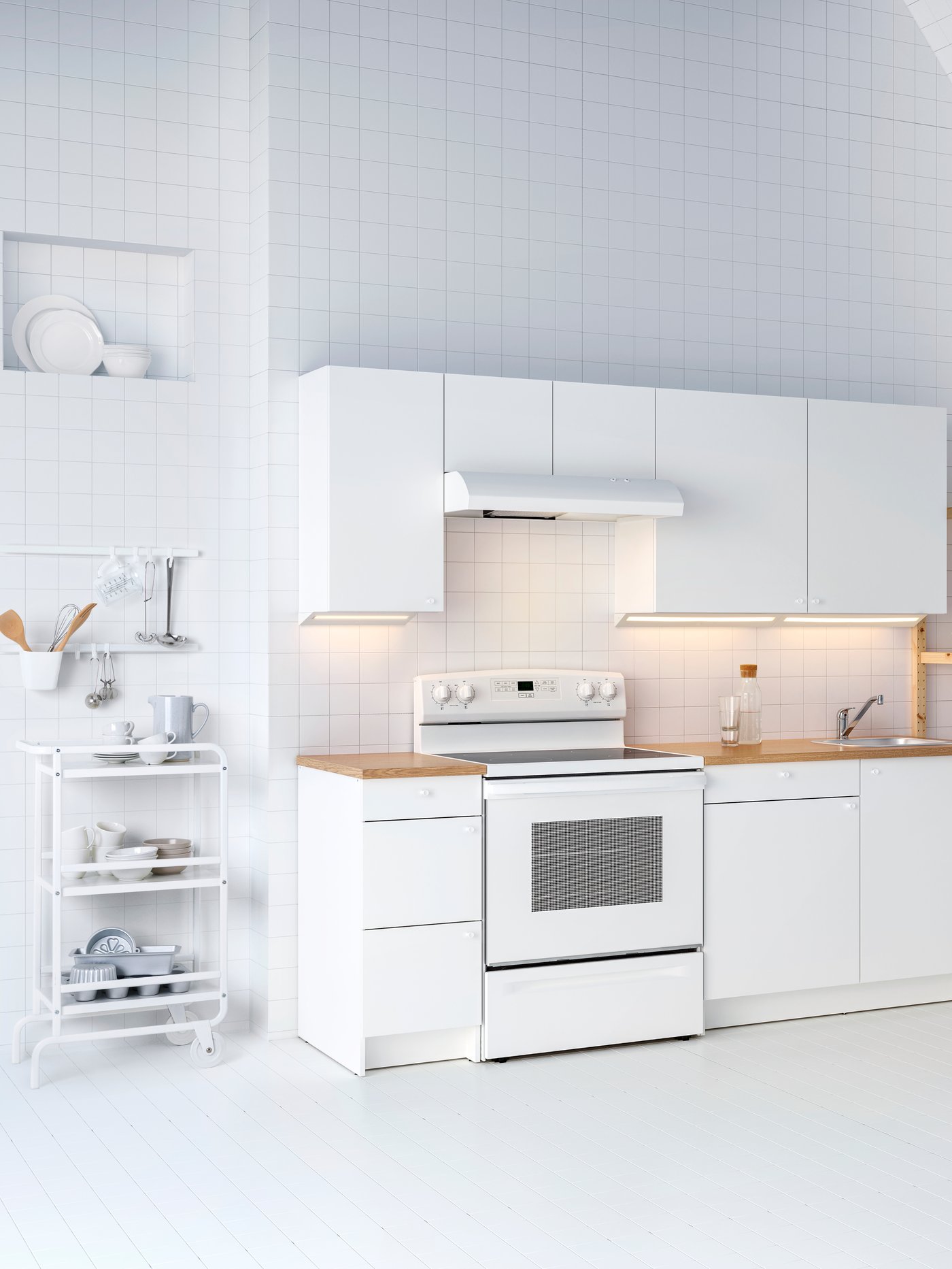 Cocina con varios armarios bajos con cajones, armarios de pared con puertas, un carrito, una placa y un extractor.