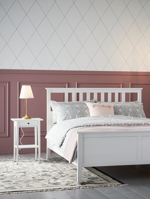 Bedroom with white bed frame, quilt cover and pillowcases set, white bedside table, table lamp, cushion cover, throw, rug.